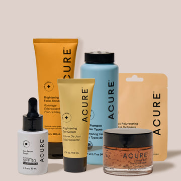 Collection of Acure skincare products on a beige background